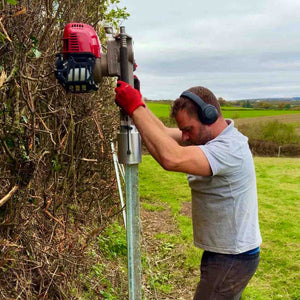 Person using a post driver on a Clipex Fence in a field