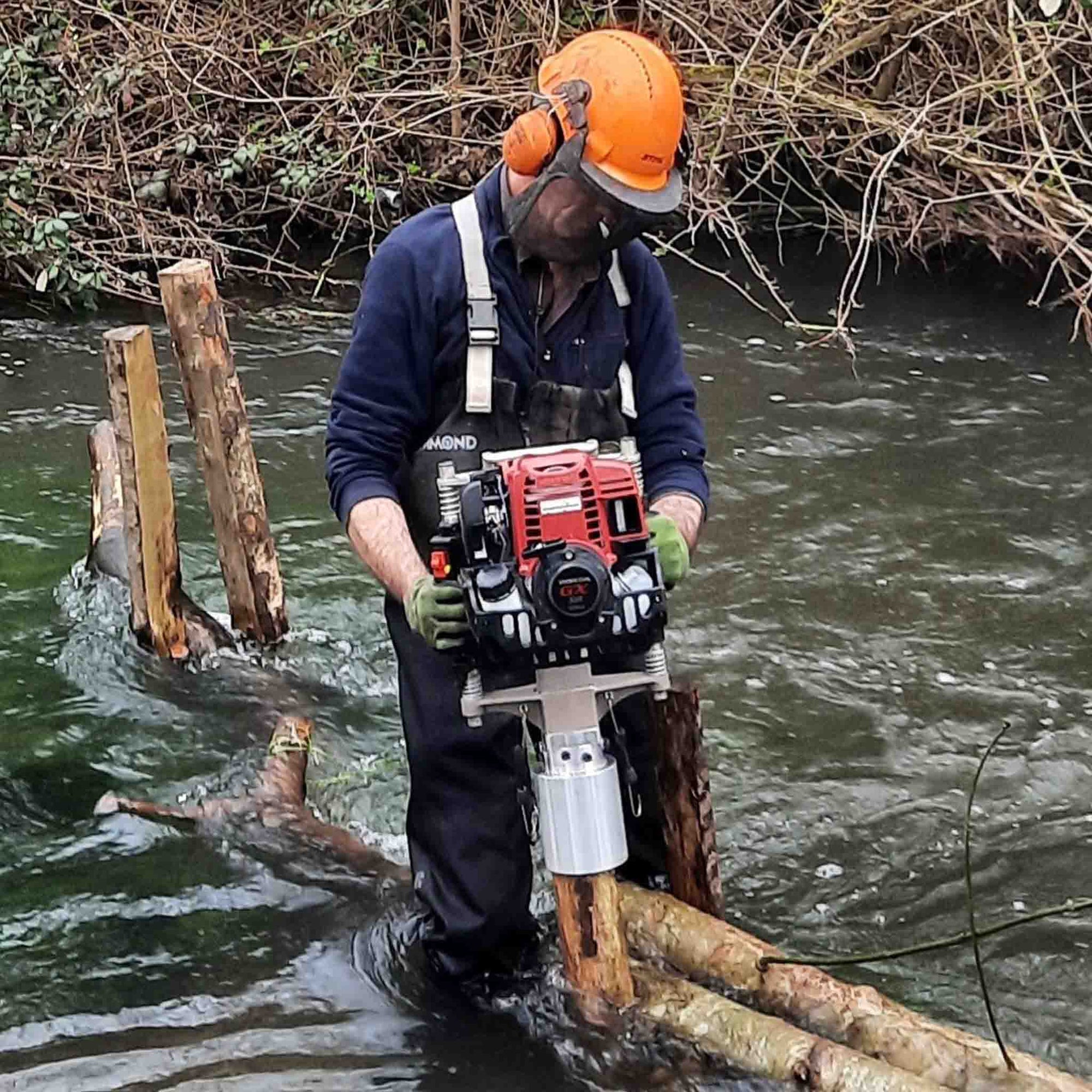 Specialist contractors installing a timber post in a Trout Fishing river