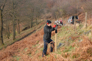 Post Driver being used to install a fence on a steep hillside, with 80mm timber posts