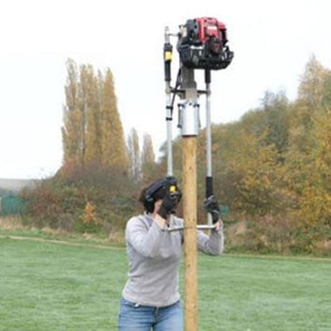 Person using petrol post driver to install a long post using extension handles