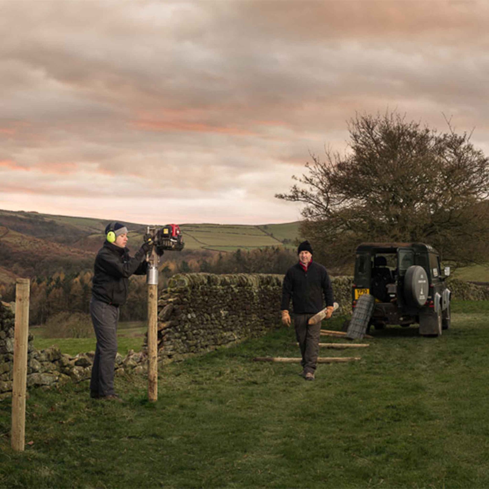 Fence posts installed alongside a crumbling wall