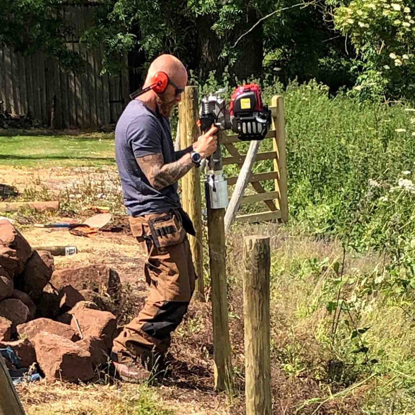 4" round timber post being installed in the ground using Easy Petrol Post Driver
