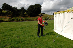 Marquee pins being installed to fasten down guide ropes on a traditional marquee