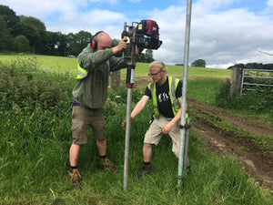 Installation of scaffold poles for an event in a field, using easy petrol post driver